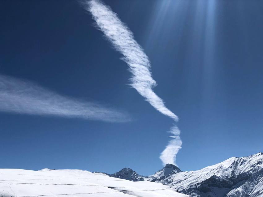 Wind-swept cloud above snowy peaks