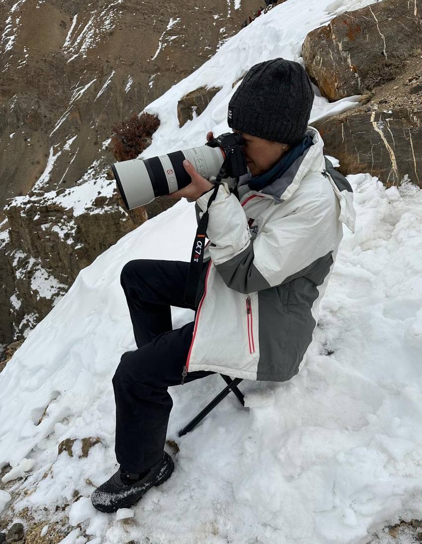 A guest photographing with a long lens from a snowy slope